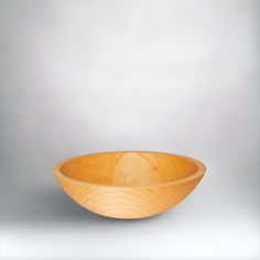 a wooden bowl sitting on top of a white countertop next to a gray wall