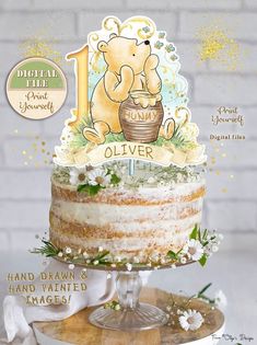 there is a cake with a bear on it and the words welcome baby written in gold