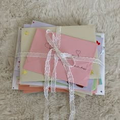 several envelopes tied together with ribbons on a white carpeted surface, some have hearts written on them