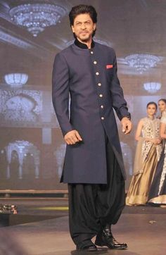 a man standing on a runway in a blue suit