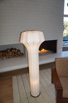 a white lamp sitting in front of a fire place