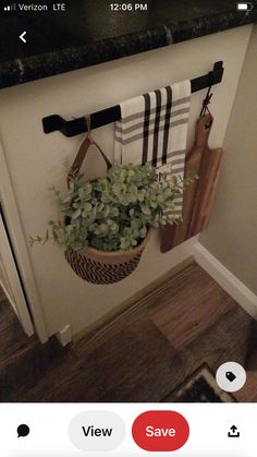 a potted plant is hanging on the wall next to a towel rack and cutting board