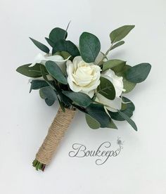 a bridal bouquet with white roses and green leaves on a burlocked handle