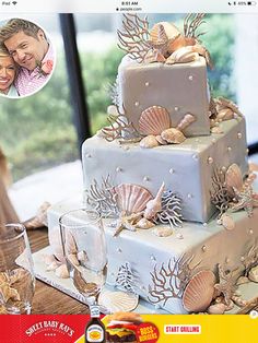 a wedding cake with seashells on it and a photo of the bride and groom