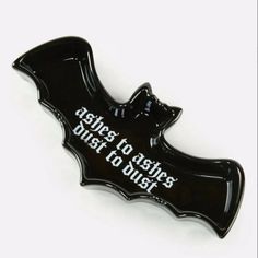 a black bat shaped pin with the words back to ashes, not to dust on it