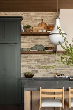 a kitchen with green cabinets and wooden chairs