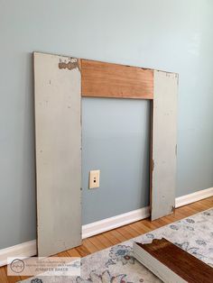 an empty room with a light switch on the wall and a door in the middle