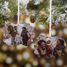 three ornaments hanging from a christmas tree decorated with family photos and pineconi cones