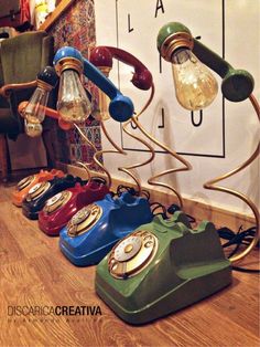 an assortment of old - fashioned telephones are lined up in a row on the floor