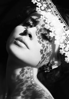 black and white photograph of a woman's face with flowers on her veil over her head