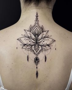 a woman's back with a lotus tattoo on it