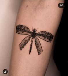 a black and white photo of a dragonfly tattoo on the right arm, it looks like an insect