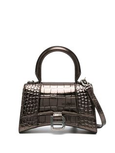 Hourglass XS croc-embossed tote bag from BALENCIAGA featuring bronze-tone, calf leather, embossed crocodile effect, monogram plaque, adjustable detachable shoulder strap, single circular top handle and foldover top with magnetic fastening.Width 7,48 in / 19 cm Height 4,72 in / 12 cm Depth 2,36 in / 6 cm Handle 2,76 in / 7 cm Balenciaga Hourglass Bag, Balenciaga Tote, Balenciaga Women, Brown Shoulder Bag, Balenciaga Bag, Browning, Leather Tote Bag, Leather Top, Womens Tote Bags