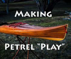 a wooden canoe sitting on top of a stand in the grass with words making petrel play