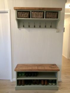 a wooden bench sitting in front of a wall with baskets on it and shoes below