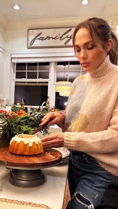 a woman cutting a cake on top of a wooden tray