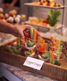 a tray filled with carrots, celery and broccoli on top of a counter