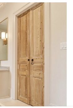 a bathroom with a sink, mirror and wooden doors