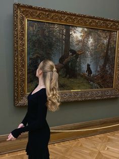 a woman standing in front of a painting