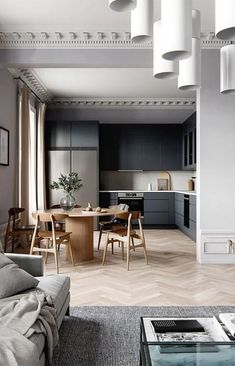 a living room filled with furniture next to a kitchen and dining room table on top of a hard wood floor