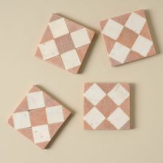 four pink and white marble coasters sitting on top of a table next to each other