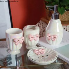 a bathroom set with pink bowknots and soap dispenser on a glass table