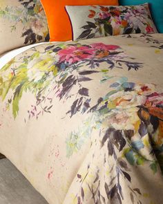 a bed covered in a floral comforter and pillows