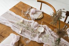 a wooden table topped with plates and glasses