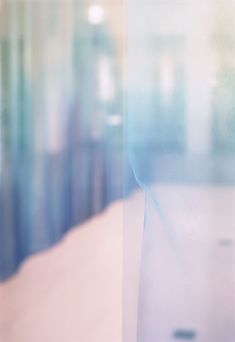 a blurry photo of a bed in a room with blue curtains on the windows