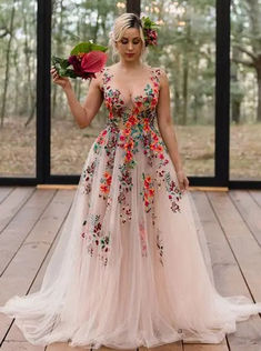 a woman standing on a wooden floor holding flowers in one hand and a bouquet in the other