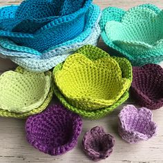 several crocheted baskets with flowers in them