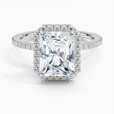 an engagement ring with a princess cut diamond surrounded by pave diamonds