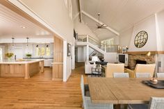 a large open concept living and dining room with wood flooring, white walls and ceiling