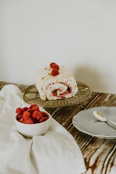 there is a plate with some food on it and another plate has strawberries in it