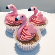 two cupcakes with pink frosting shaped like flamingos