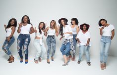 a group of women standing next to each other in front of a white background with one woman giving the peace sign