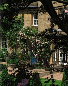 a large house with lots of flowers in the front yard