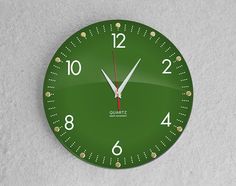 a green clock with white hands and numbers on the face is shown in front of a gray background