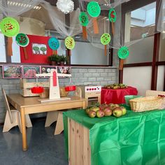 the table is set up with apples and paper decorations