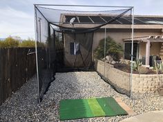 a backyard area with a golf mat and net