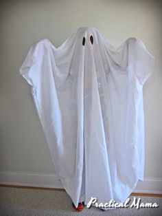 a white ghost costume hanging on the wall