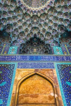 the entrance to an ornate building with blue and gold tiles on it's walls