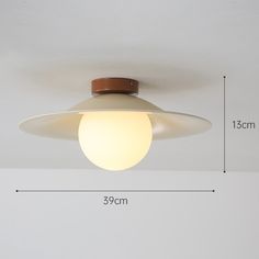 a white ceiling light with a brown wooden trim and an orange light bulb on it