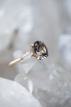 an engagement ring with a brown and white diamond in it sitting on top of ice