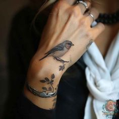 a woman with a bird tattoo on her wrist