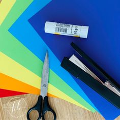 a pair of scissors sitting on top of a table next to some pens and paper