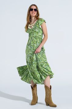 Introducing our enchanting Midi Romantic Dress with Ruffled Short Sleeves in Green Leaf Print, a charming piece that exudes timeless elegance and feminine allure. This lovely dress features romantic ruffled sleeves and a flattering V-neckline with a delicate keyhole detail at the chest.  Crafted from lightweight woven fabric made of 100% viscose, this dress is perfect for daily wear. The midi length and A-line skirt adorned with a sweet leaf print in different shades of green create a whimsical and romantic look.  With its standard fit, this dress offers a comfortable and flattering silhouette that's suitable for any occasion. The open tie back adds a playful touch to the design, while the lining made of 100% viscose ensures opacity and comfort.  The model effortlessly showcases its beauty