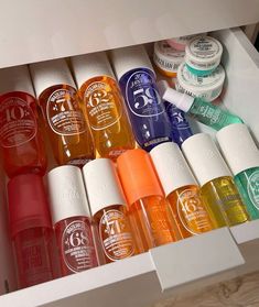 an open drawer with many different colored bottles in it