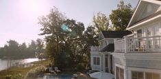 an aerial view of a house with a swimming pool in the foreground and trees on the other side