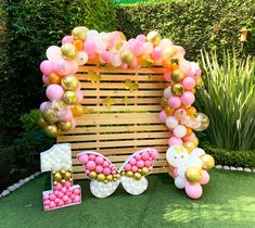 the balloon arch is decorated with pink, gold and white balloons